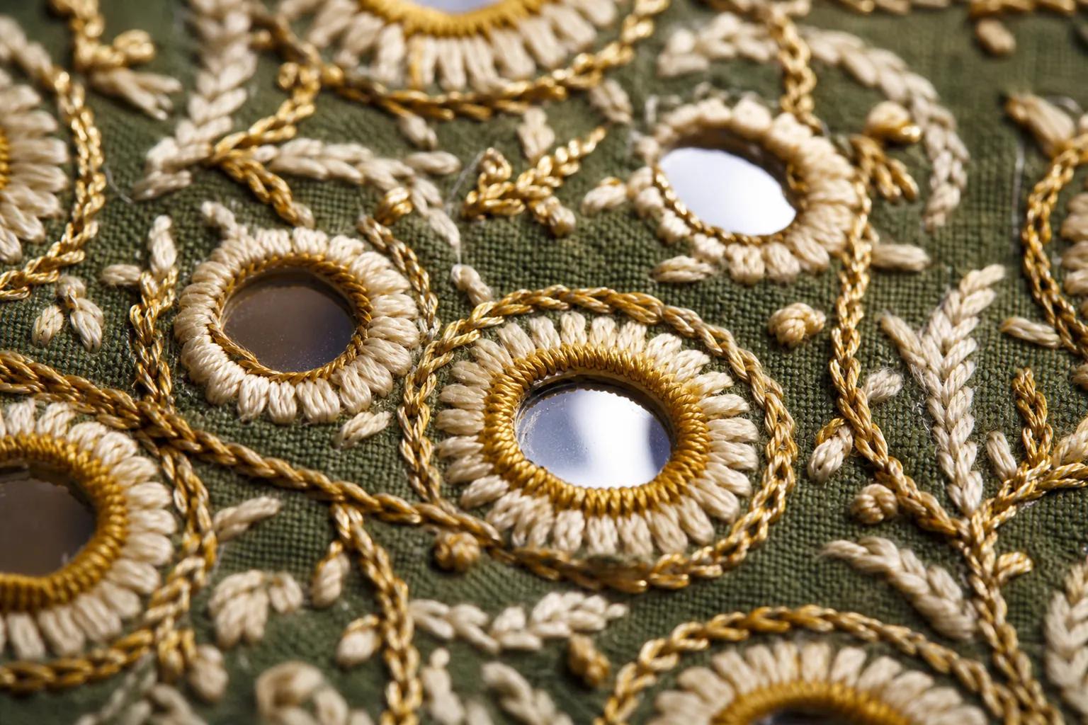 Shisha mirror work embroidery held by gold thread rings on sage cotton